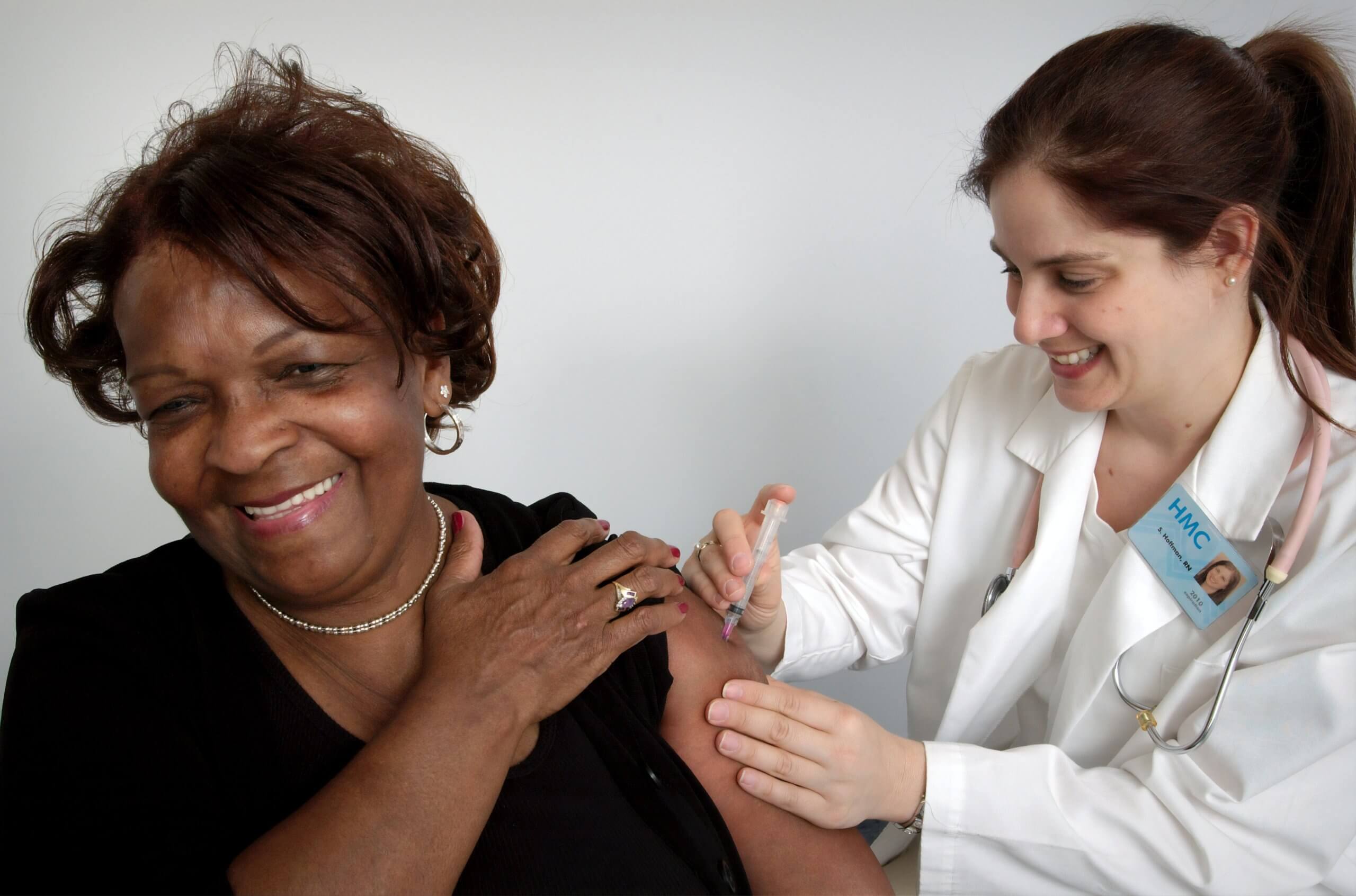 nurse giving vaccine shot to a woman
